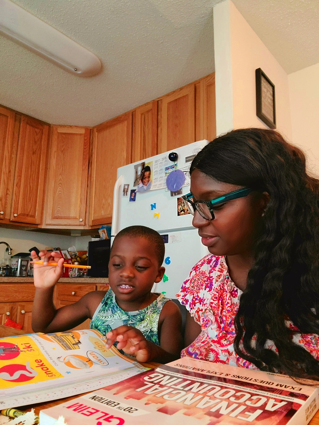 Comfort and her son studying together at he kitchen table.